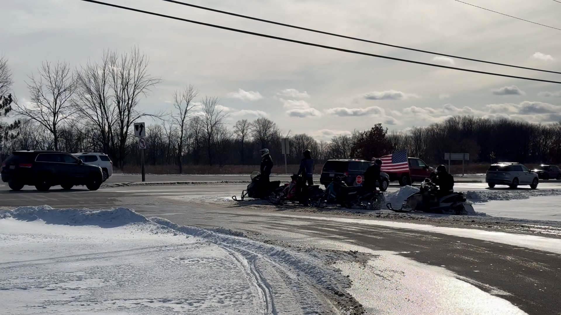 Snowmobiles waiting to cross a Wisconsin state highway