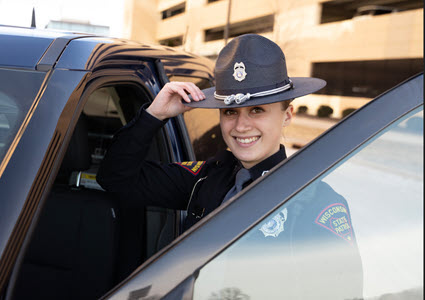 Smiling female State Patrol Trooler getting into car