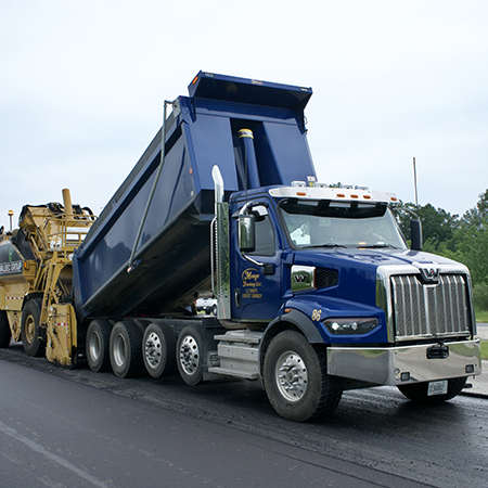 A blue dump truck on a construction site.