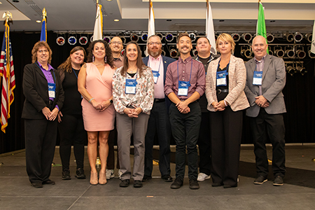 Group photo of WisDOT Tribal Affairs Team, ten staff members  standing on a stage