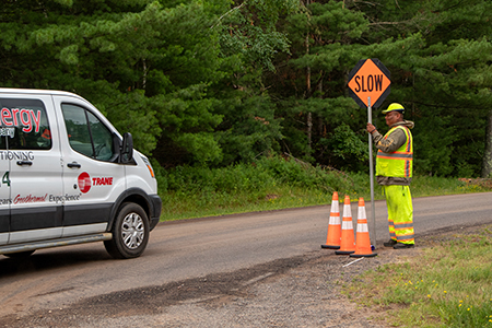 A flagger is approached by a van in a work zone.