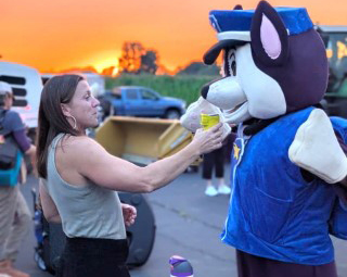 Chem test technician standing with a person in a K-9 officer costume at a community event