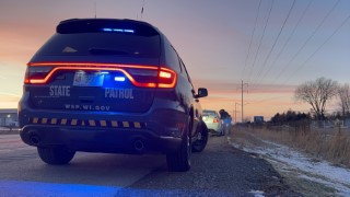 A Wisconsin State Patrol Dodge Durango on a traffic stop, with a trooper making a passenger side approach to a vehicle