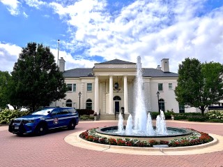 A Wisconsin State Patrol cruiser infront of the Wisonsin Executive Residence, parked next to a fountain