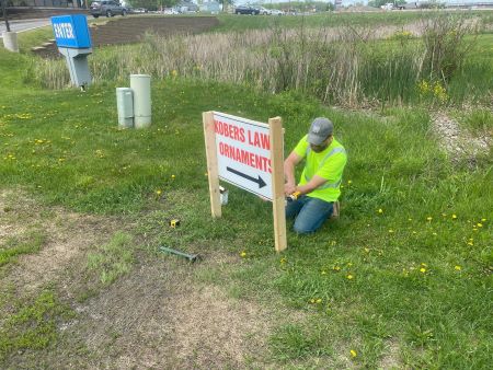 A worker installs temporary business signage.